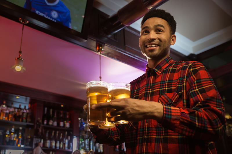 smiling-afro-american-man-carrying-glasses-beer